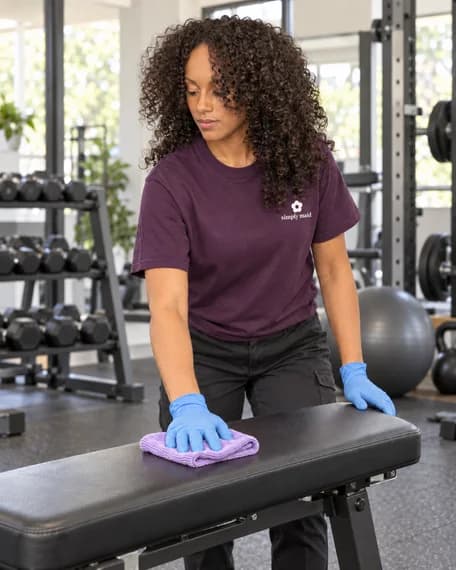Crew member carrying out gym & studio cleaning